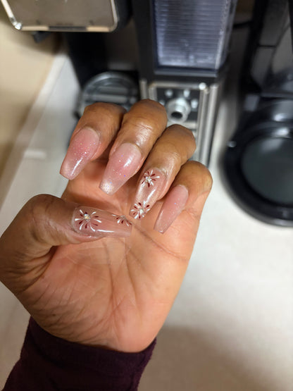 Hand with decorative nail art in a kitchen setting